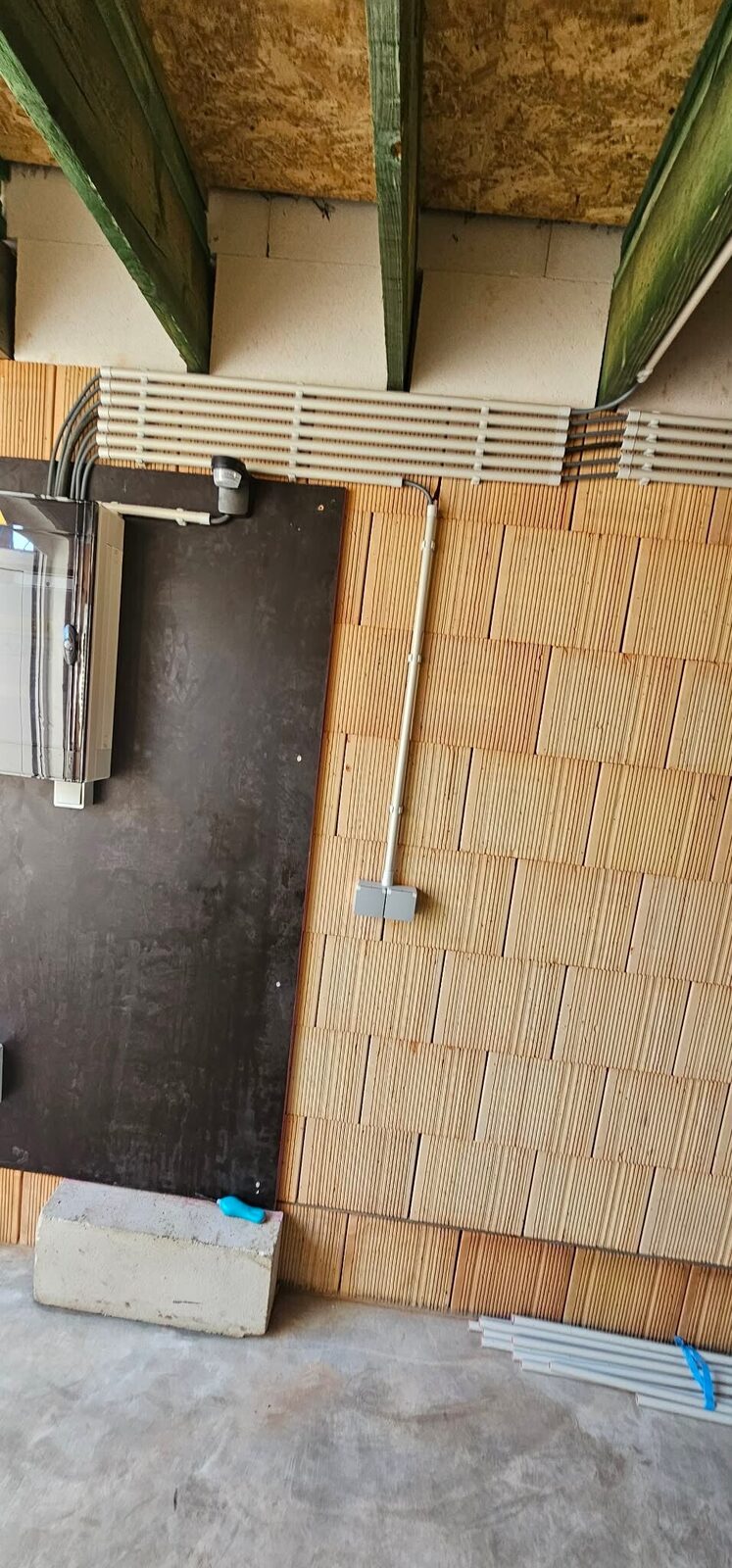 Geordende elektrische leidingen langs de muur van een woning in aanbouw